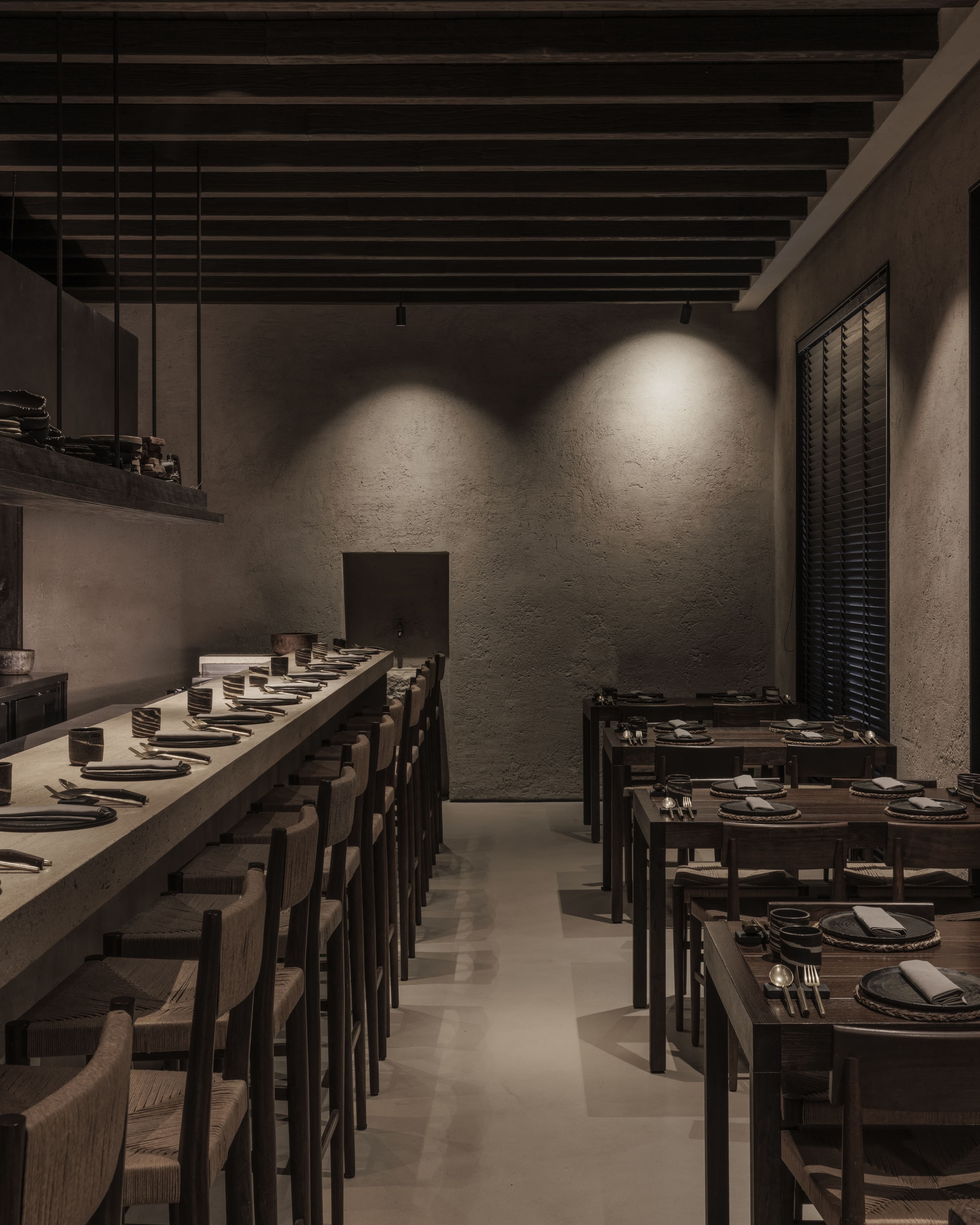 Vista della sala ristorante con bancone bar e sgabelli, velette in cartongesso e pareti in intonaco texturizzato