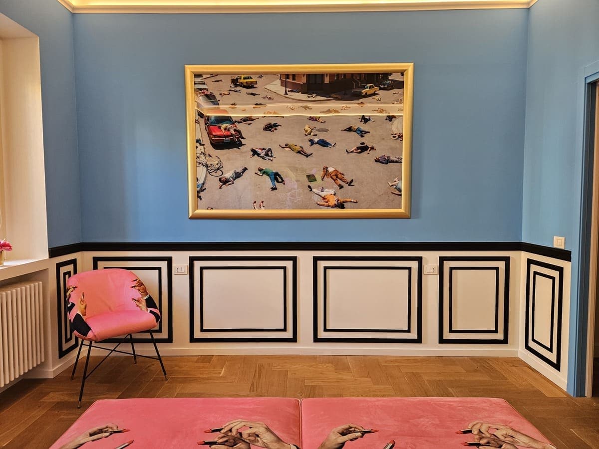 Camera con fotografia di Alex Prager, poltrona e letto Seletti rosa, boiserie e parquet a spina