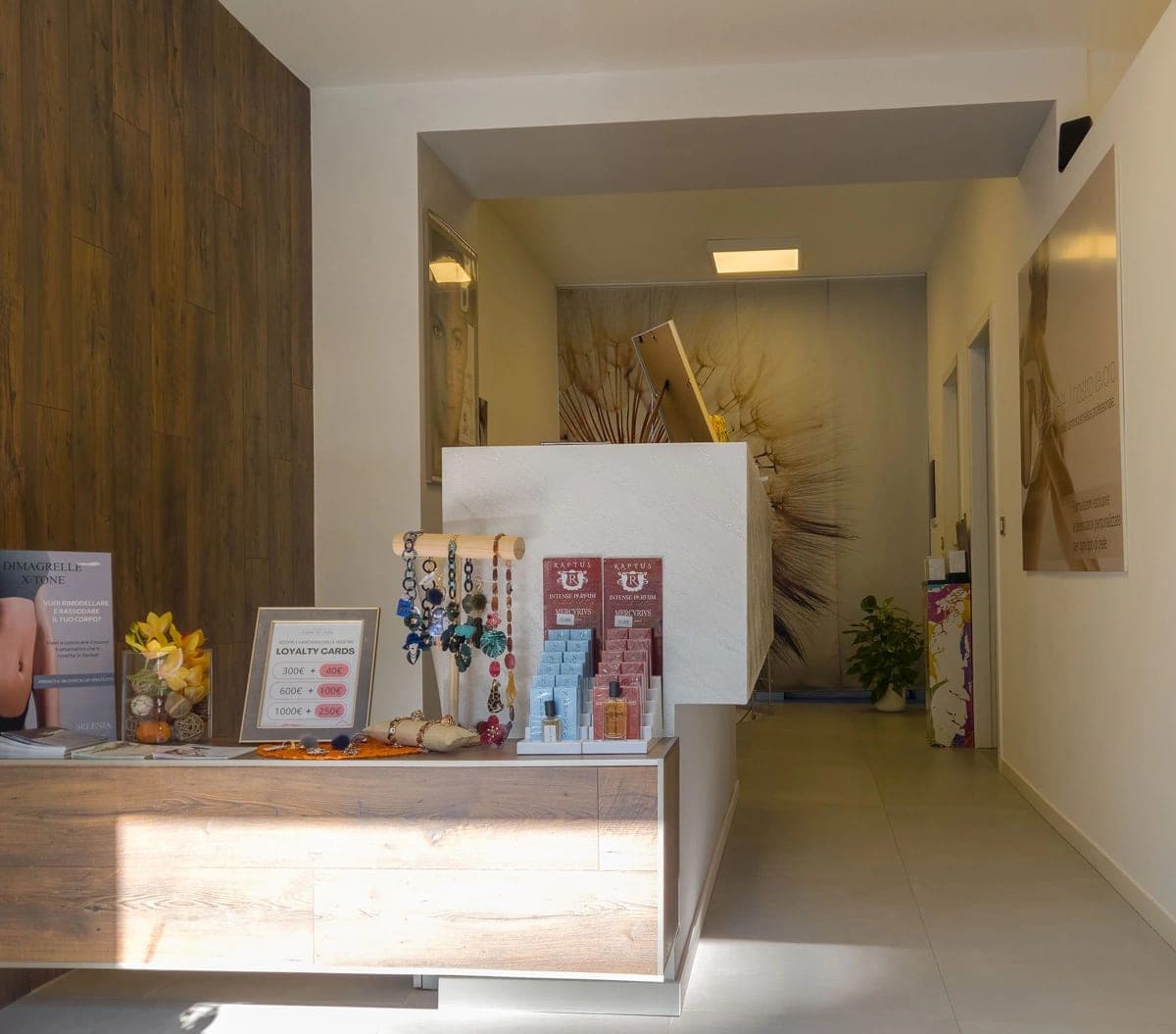 Vue frontale du comptoir réception avec exposition produits et cartes fidélité