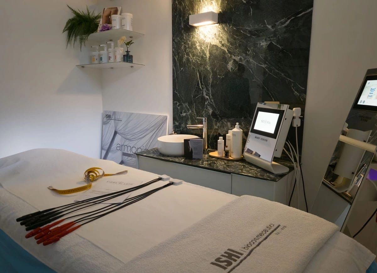 Cabine soins corps avec lit, équipements professionnels et mur effet marbre foncé