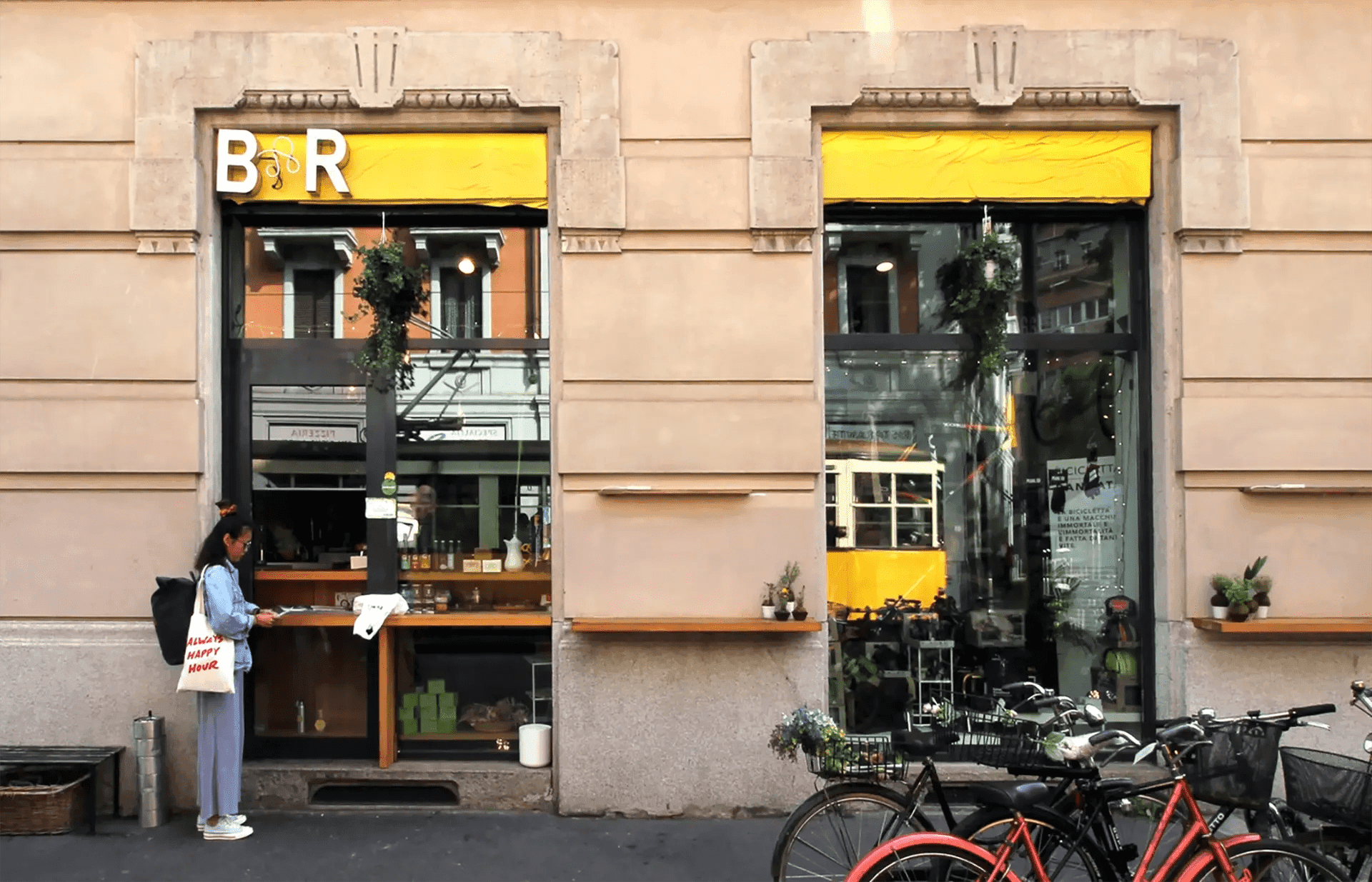 Street facade with double windows, yellow B&R sign and parked bicycles