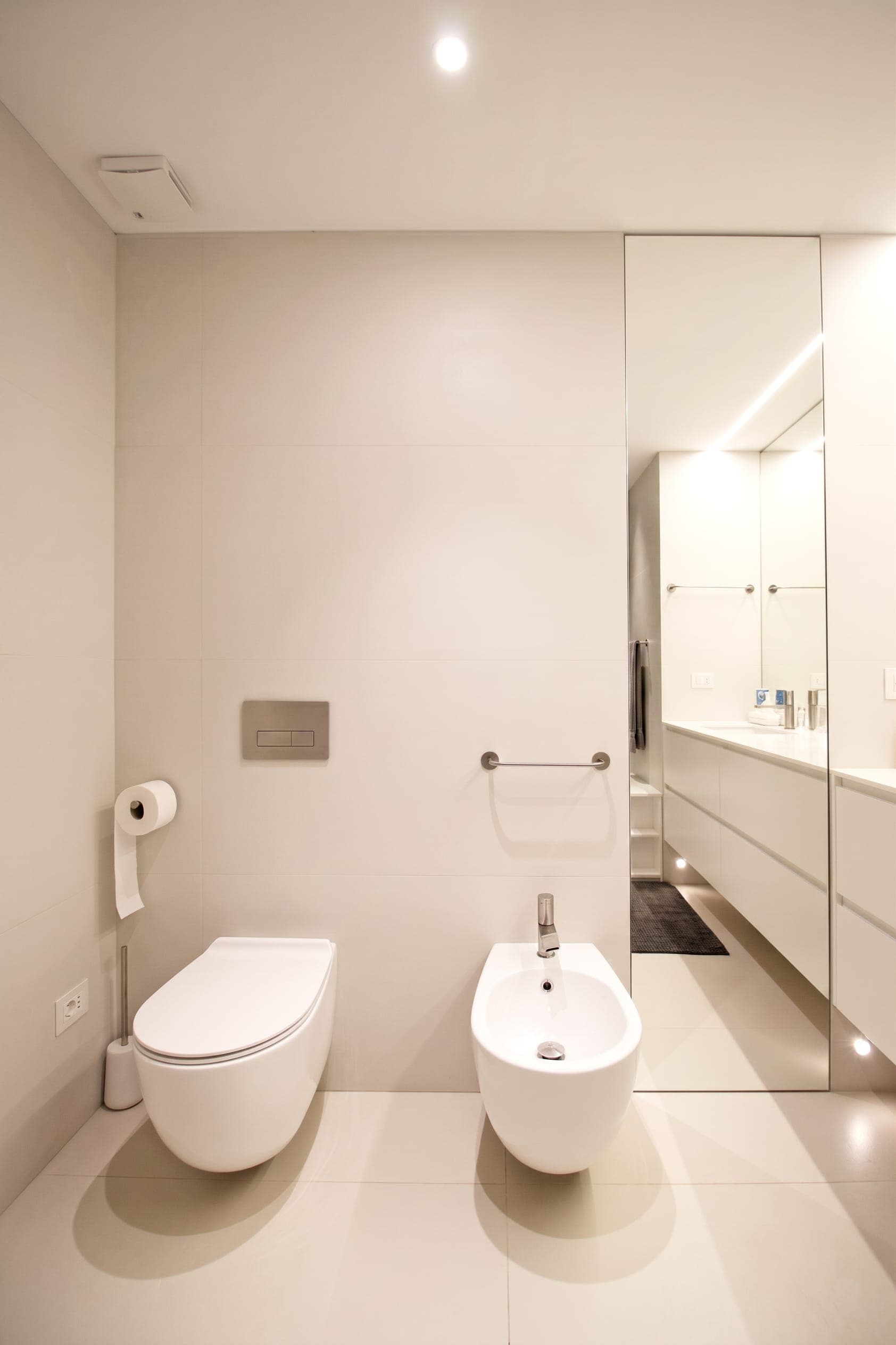 Bagno minimalista bianco con mobile lavabo e specchio