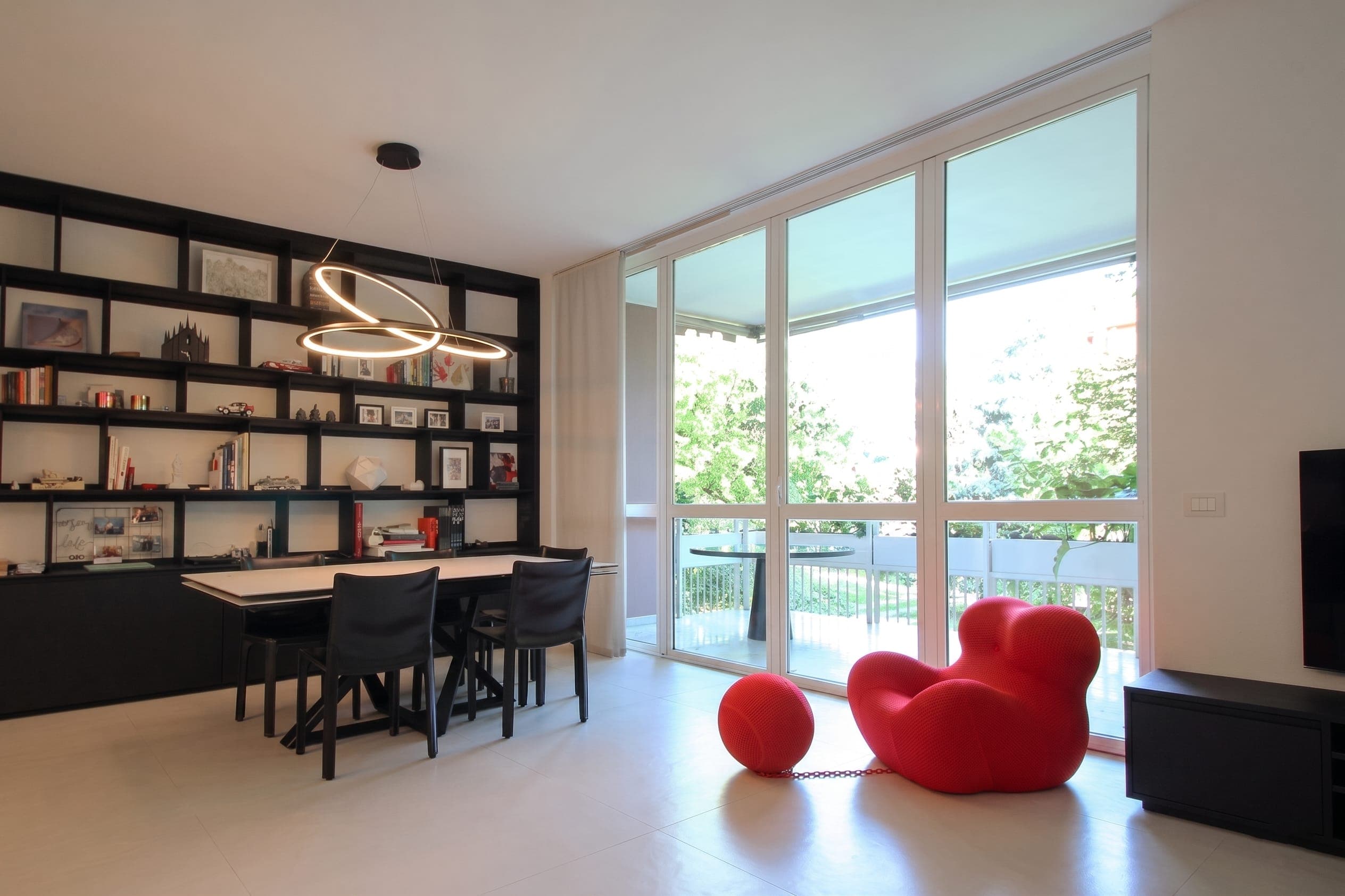 Sala musica con pianoforte a coda, grande finestra sul verde e applique