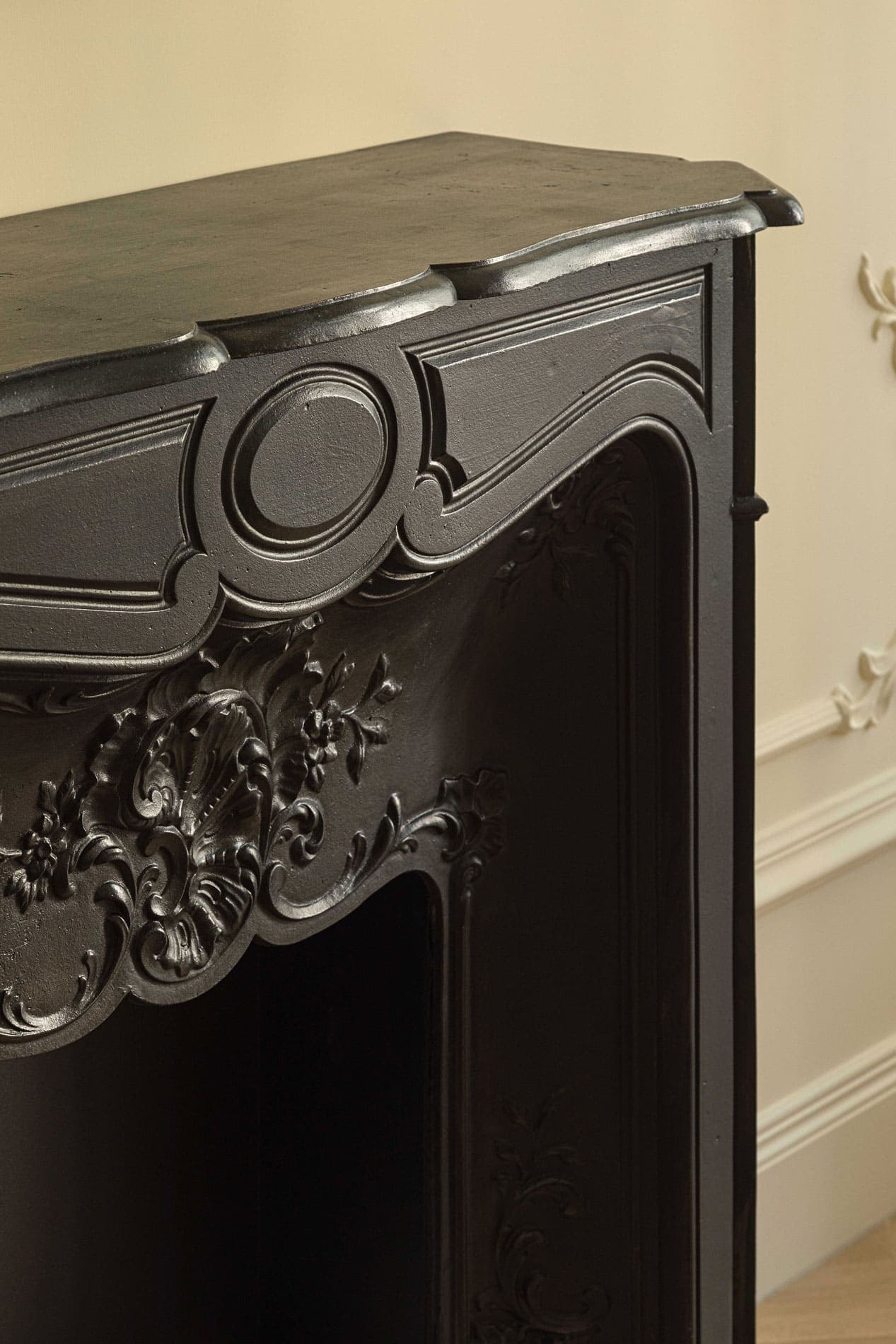 Detail of cast iron fireplace with floral carvings and decorative surround