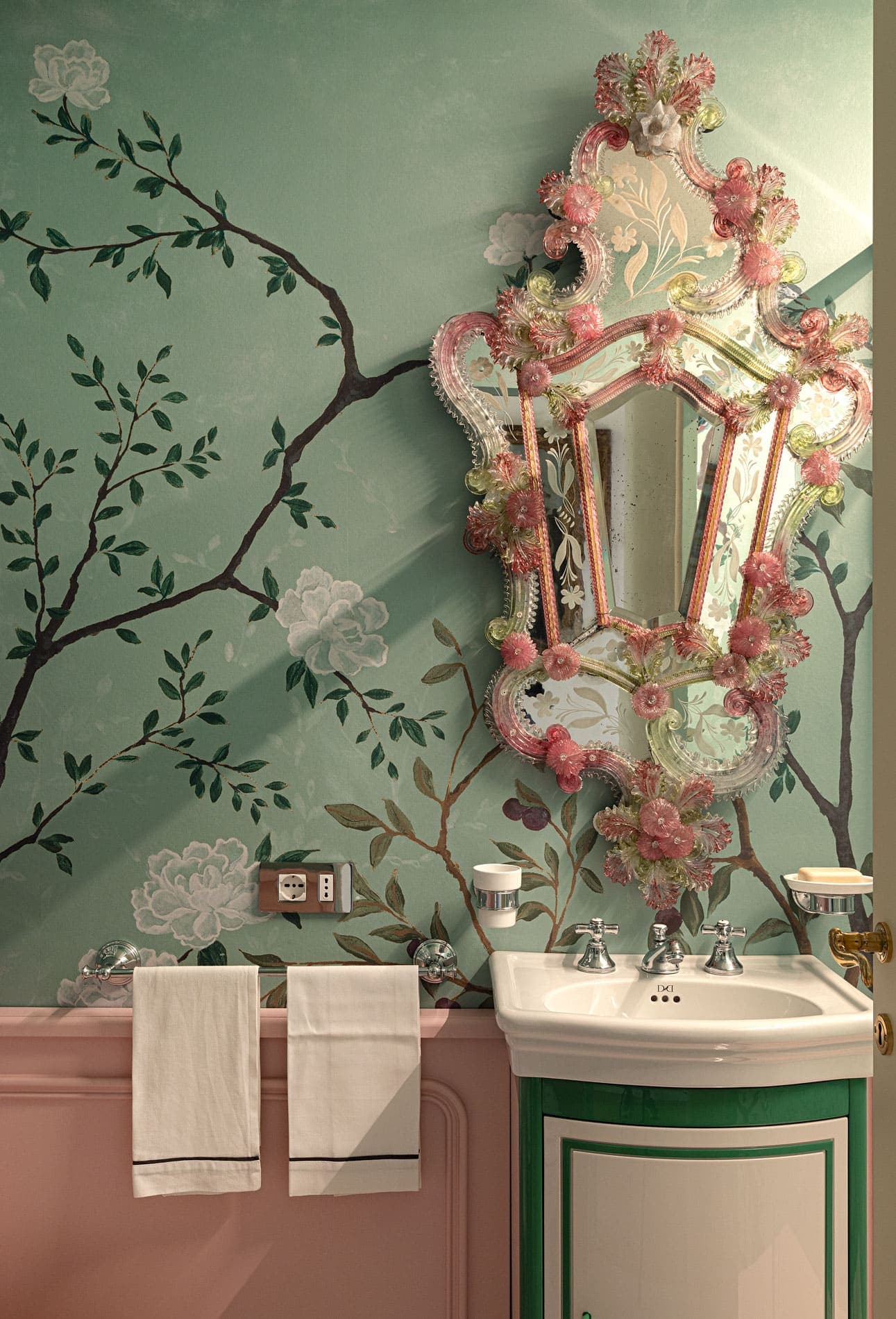 Bathroom with green chinoiserie wallpaper, pink Venetian mirror and classic basin