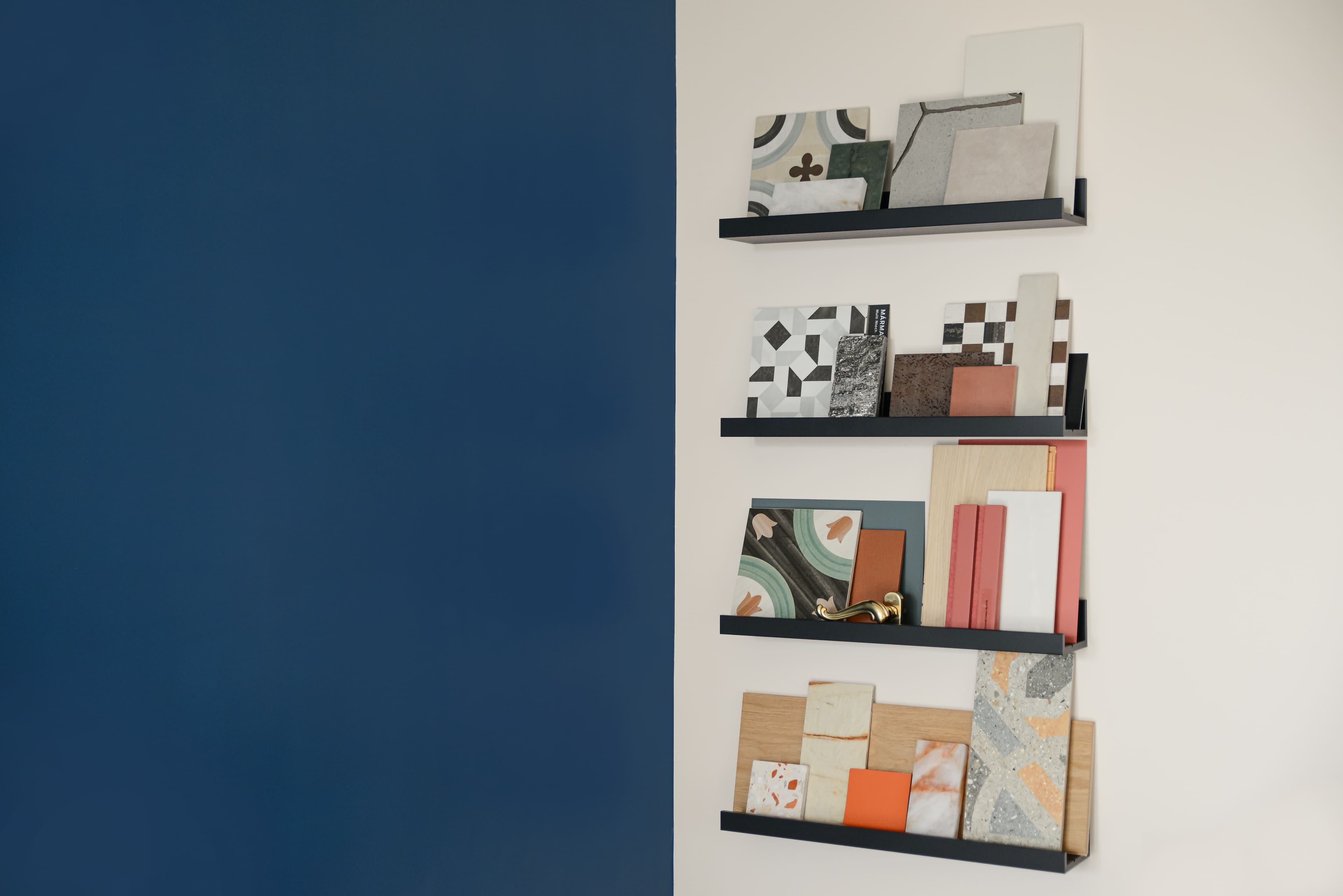 Mensole a parete con campionature di piastrelle e materiali decorativi