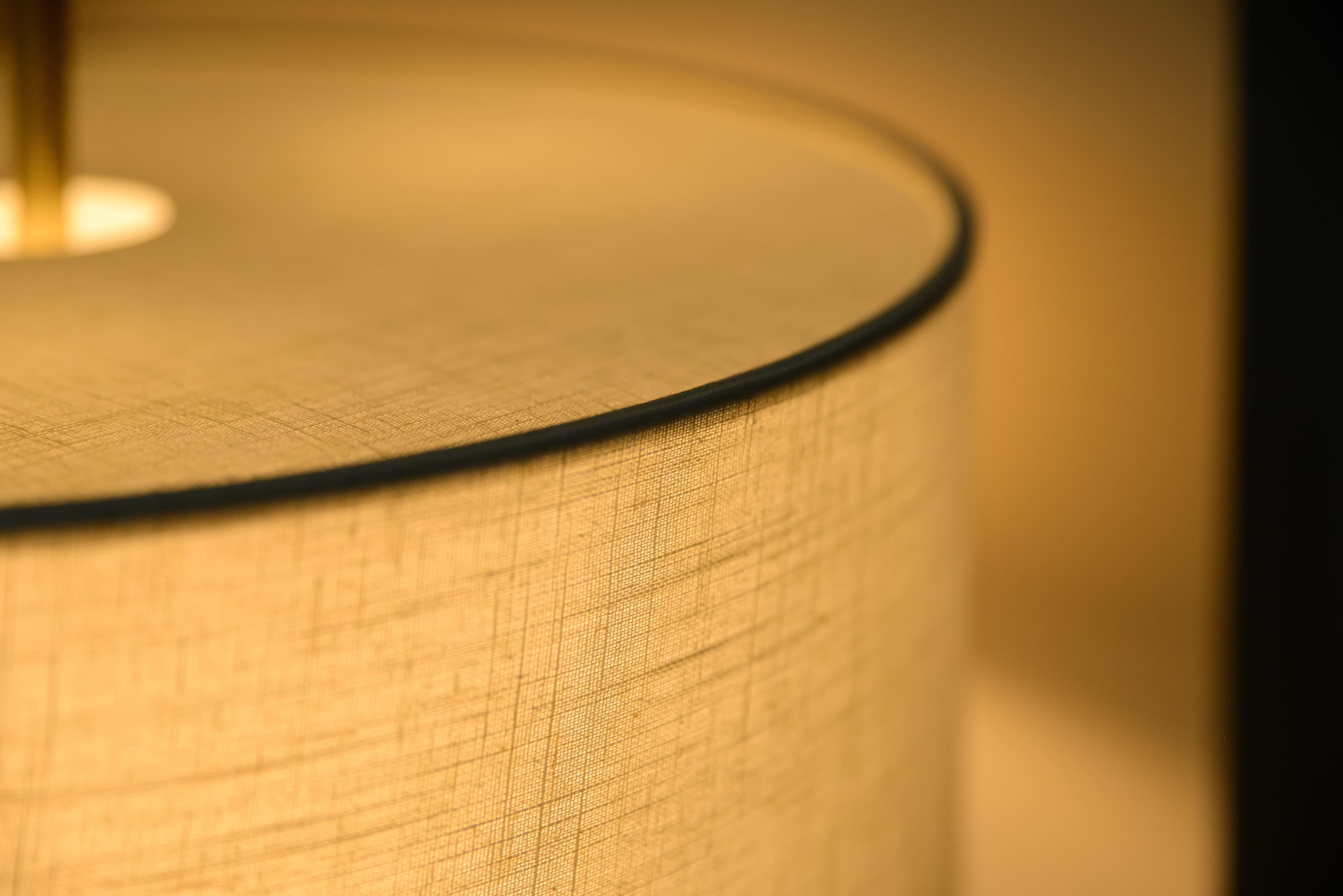 Dettaglio lampada da tavolo con paralume in tessuto e finiture in ottone