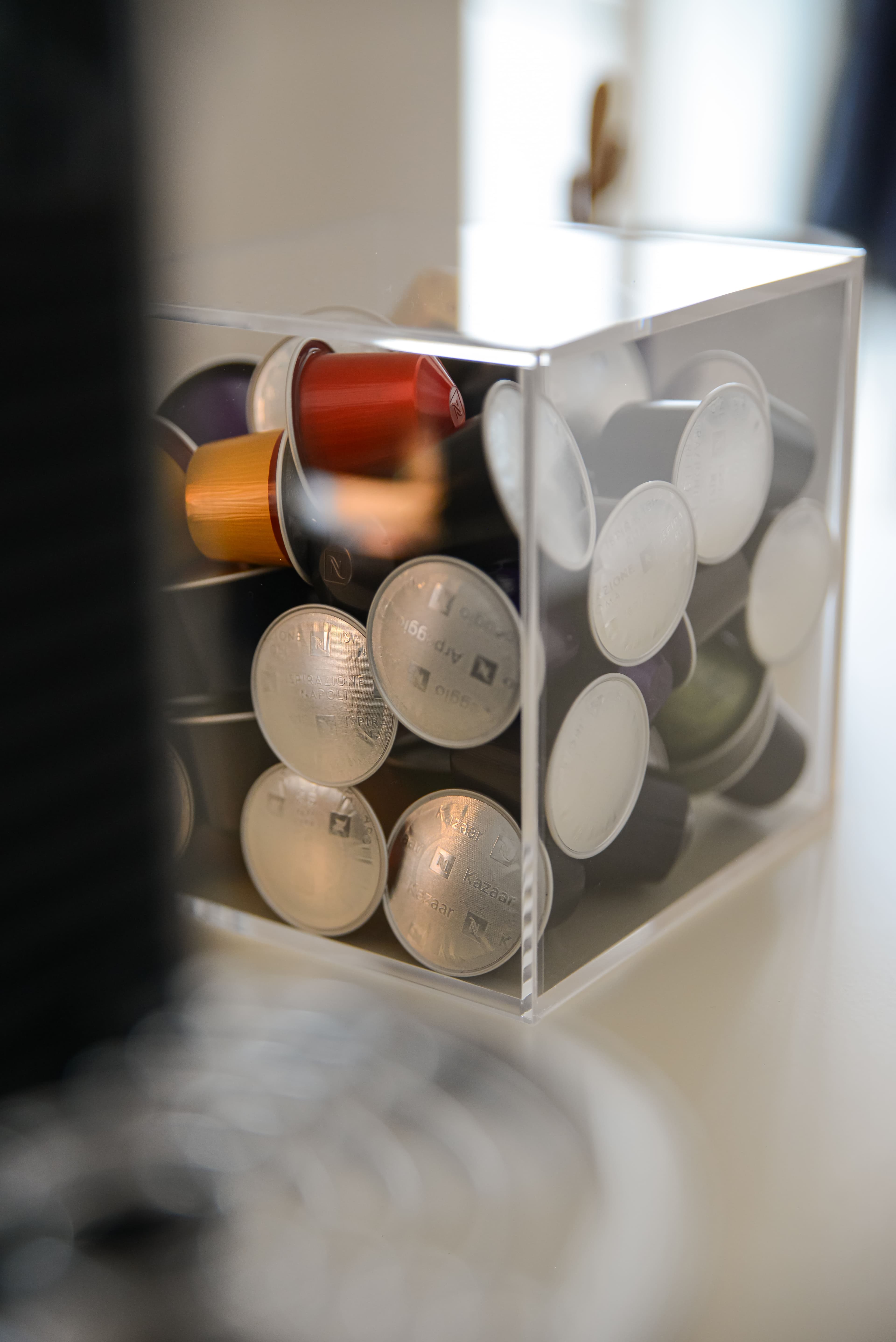Dettaglio angolo caffe con capsule colorate e macchina espresso