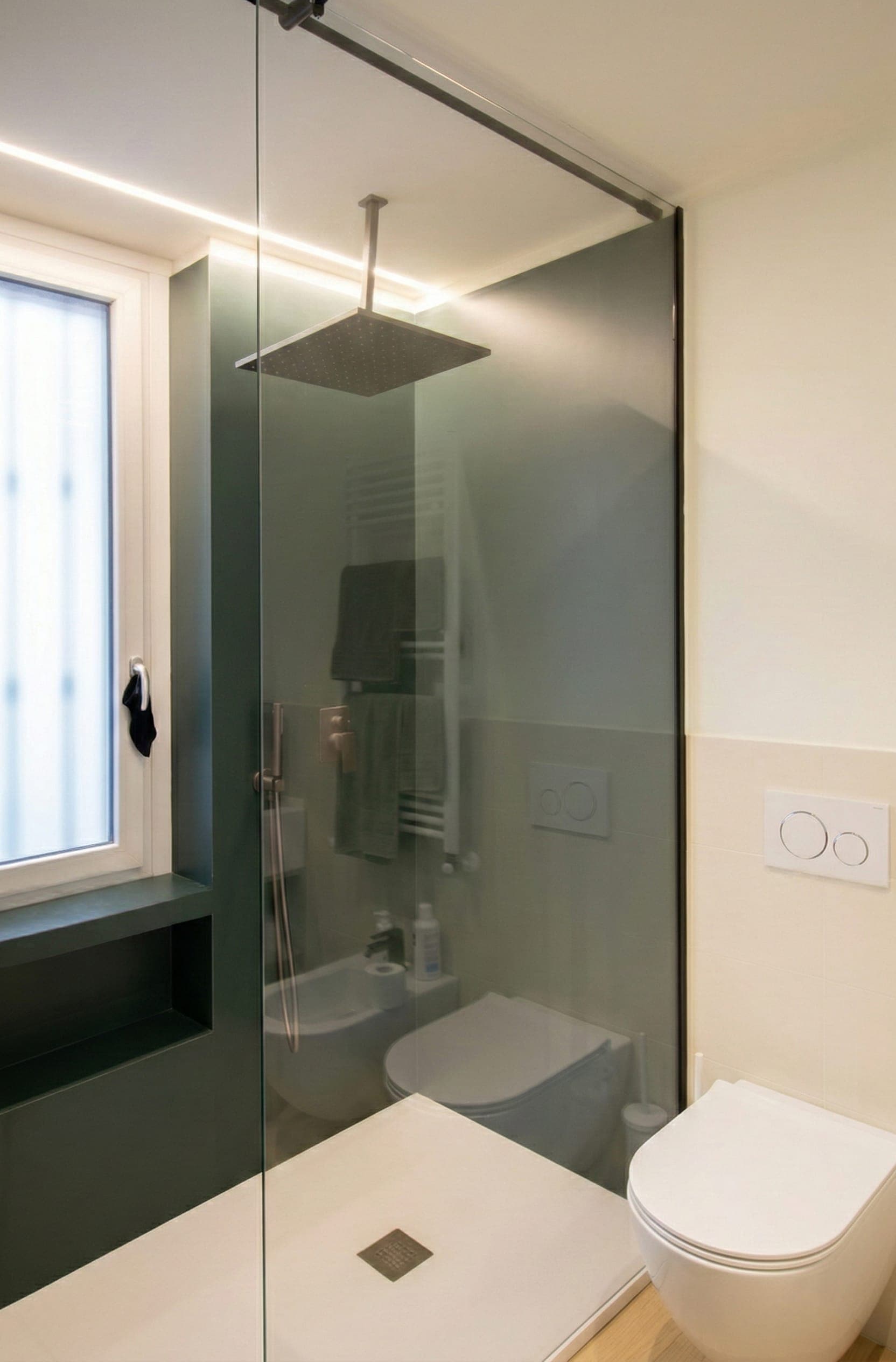 Bagno con doccia in vetro, finestra e scaldasalviette
