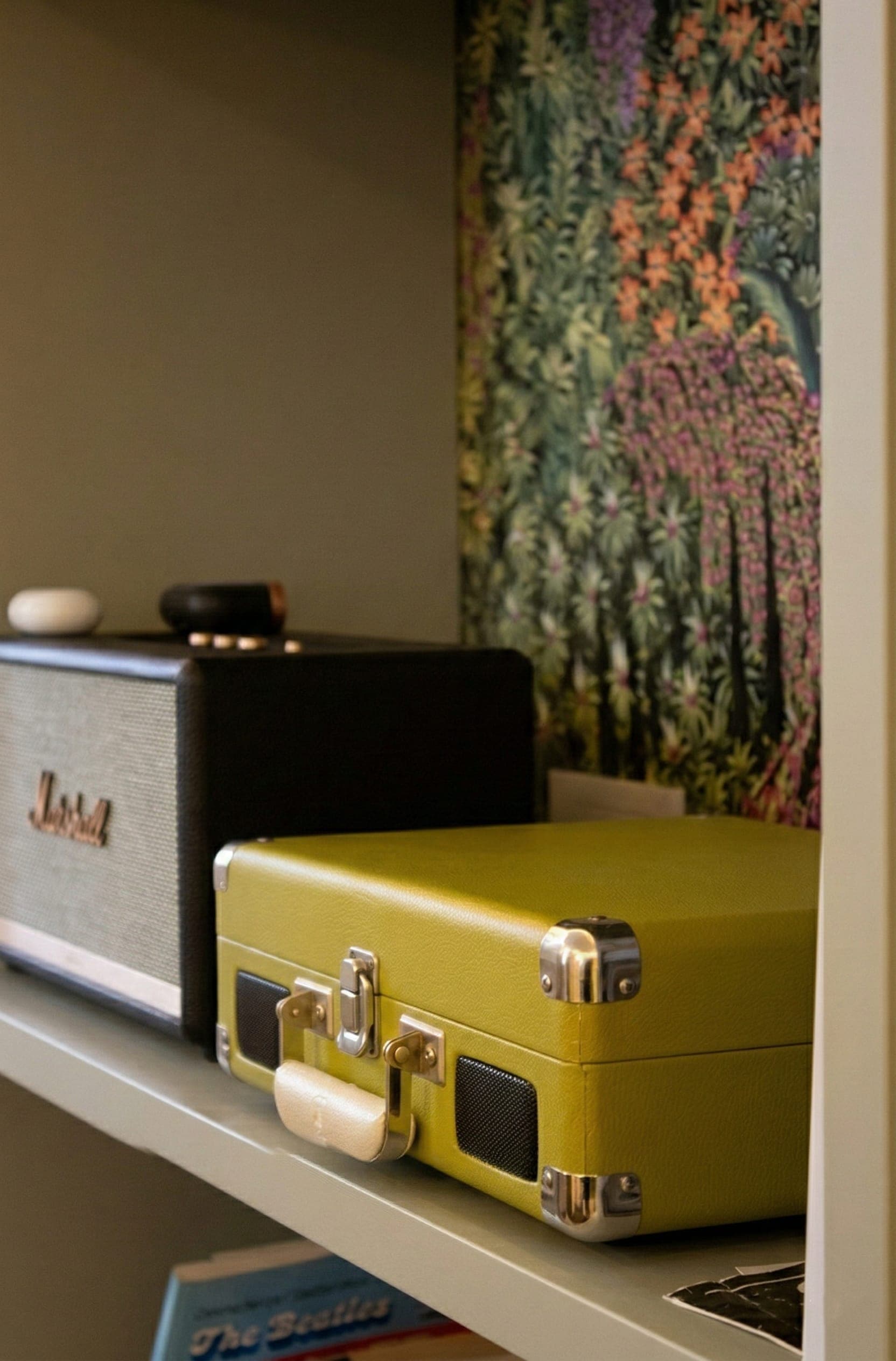 Angolo musica con amplificatore Marshall, custodia chitarra e carta da parati botanica