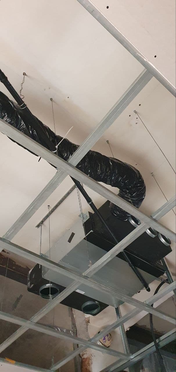 Infrastruttura impiantistica al soffitto con canalizzazioni, condotti flessibili e telaio metallico